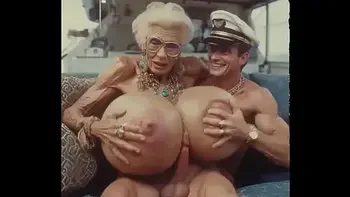 JAY7 Granny Boob Cruise 01 - AI VIDEO - A topless and horny granny with huge bolt-on tits gives a crazy titjob to the skipper