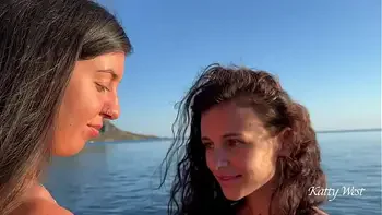 Two naked beauties swim in the sea at dawn