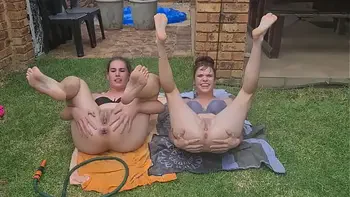 Half naked girls playing with a garden hose