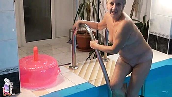 Gorgeous mature blonde Jitka is touching her shaved pussy in the pool