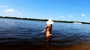 Blonde Nackte zeigt Tattoos solo am Fluss